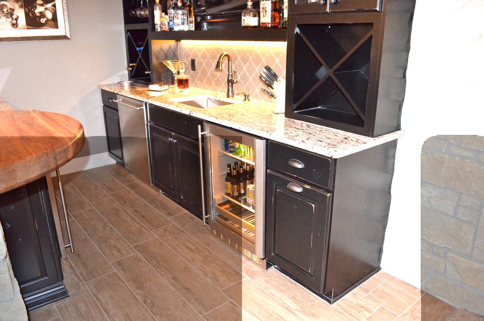 Example of a mountain style ceramic tile home design design in Omaha with an undermount sink, black cabinets, granite countertops and glass tile backsplash
