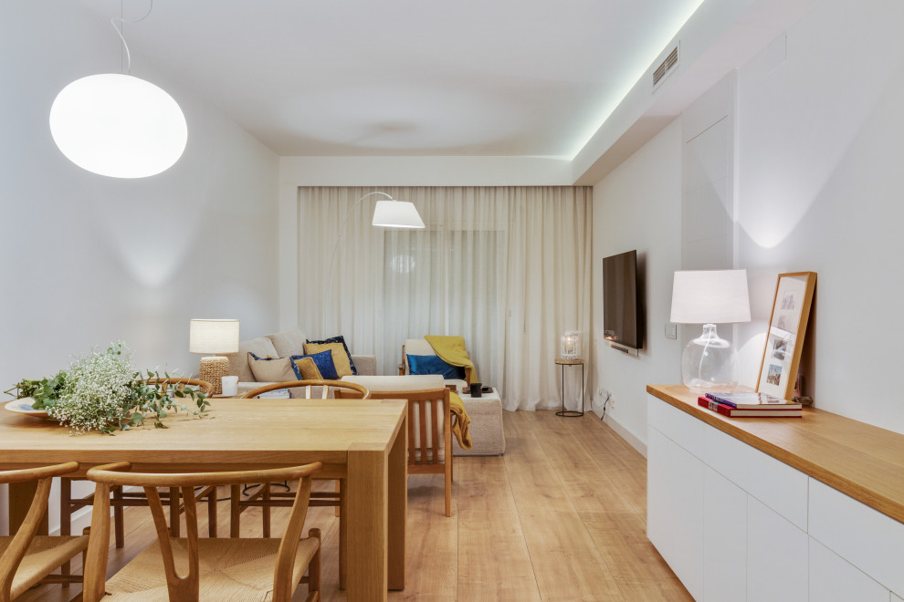 Photo of a mid-sized contemporary open plan dining in Barcelona with white walls, medium hardwood floors and brown floor.