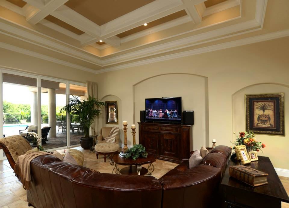 Mediterranean open concept family room in Orlando with beige walls, travertine floors and a freestanding tv.