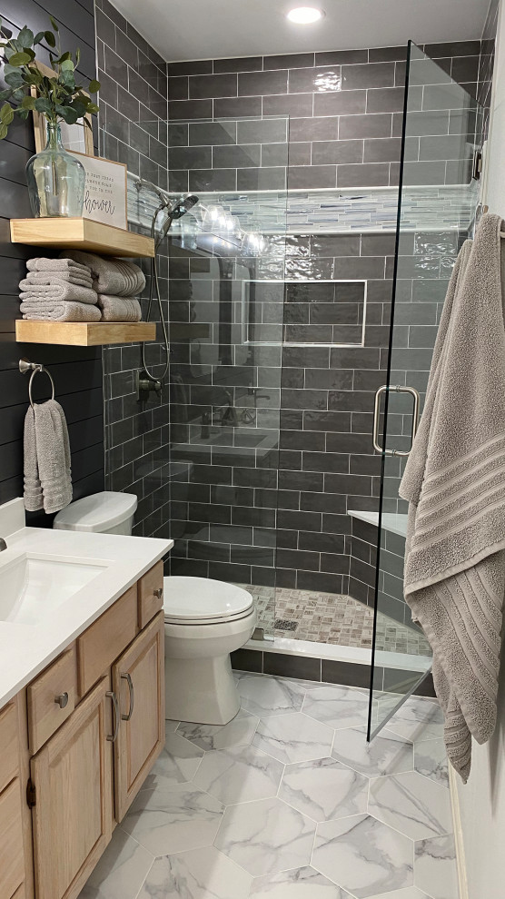 Photo of a small country 3/4 bathroom in Dallas with raised-panel cabinets, light wood cabinets, an alcove shower, gray tile, subway tile, grey walls, porcelain floors, an undermount sink, engineered quartz benchtops, grey floor, a hinged shower door, white benchtops, a shower seat, a double vanity, a built-in vanity and planked wall panelling.