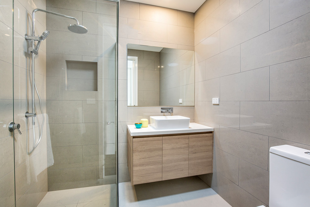 Small modern 3/4 bathroom in Melbourne with raised-panel cabinets, medium wood cabinets, a double shower, a one-piece toilet, brown tile, ceramic tile, brown walls, cement tiles, a pedestal sink, granite benchtops, white floor and a hinged shower door.