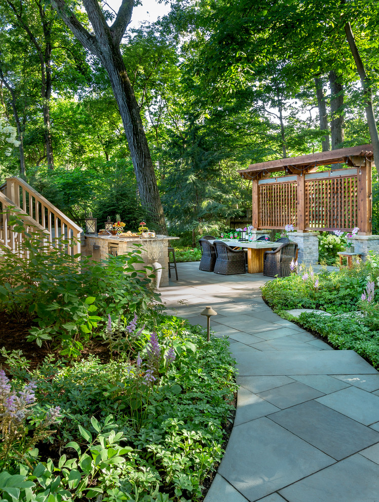 Traditional backyard shaded garden in Chicago with a garden path and natural stone pavers for summer.
