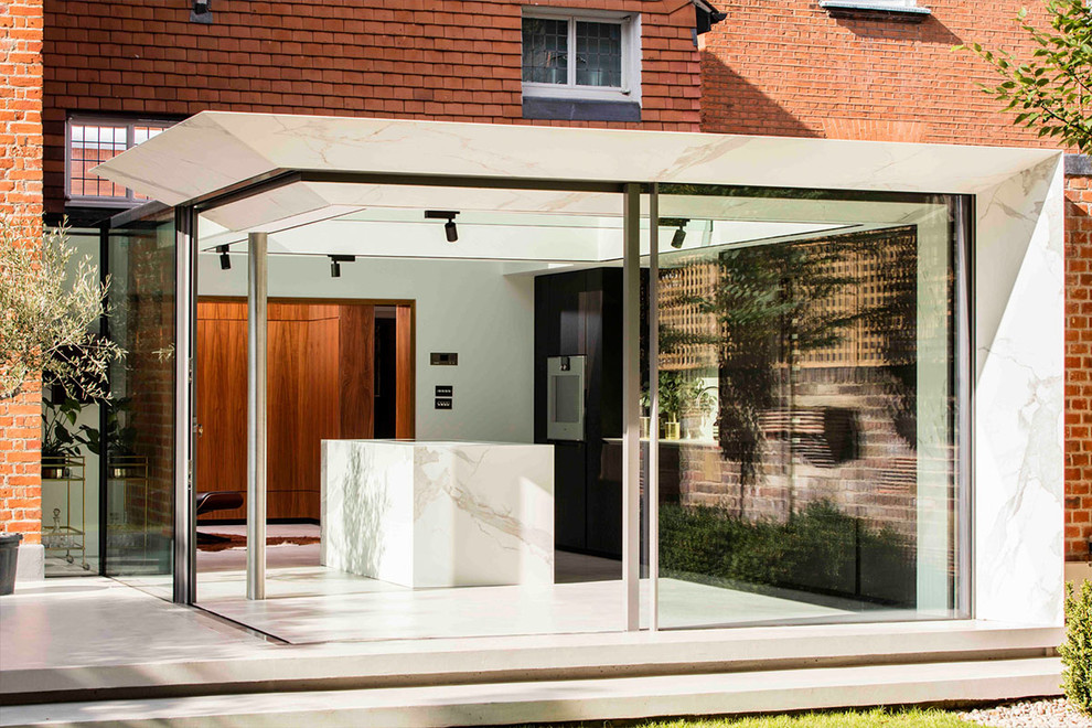 Photo of a mid-sized contemporary side yard patio in London with a roof extension.