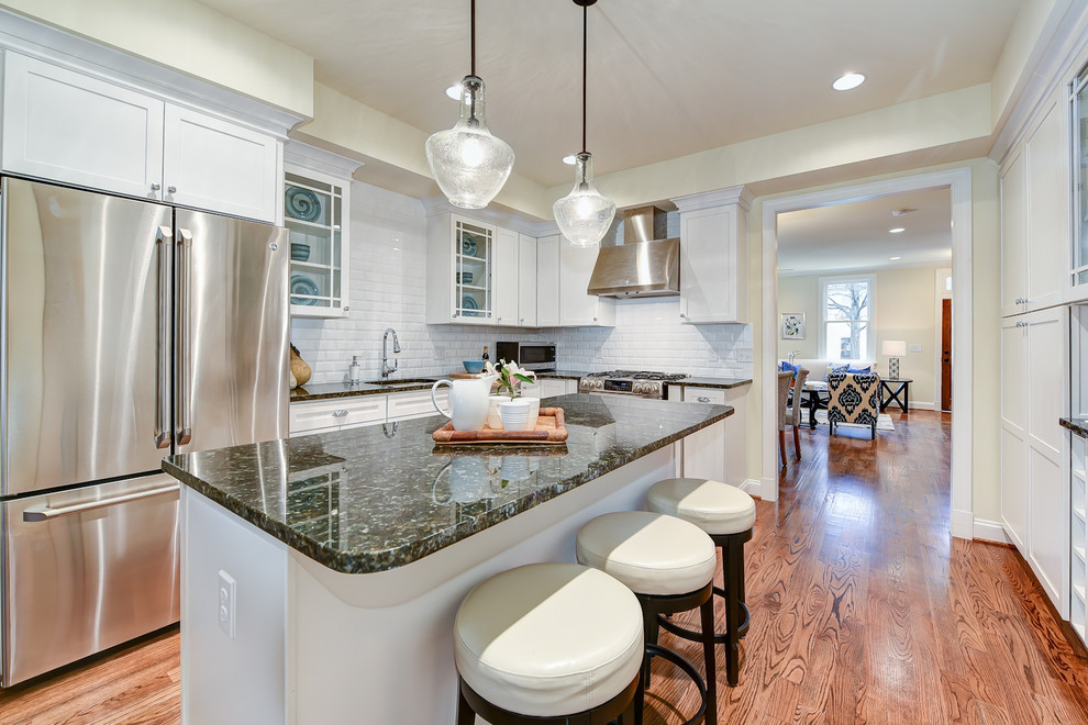Inspiration for a l-shaped medium tone wood floor eat-in kitchen remodel in DC Metro with an undermount sink, shaker cabinets, white cabinets, granite countertops, white backsplash, subway tile backsplash, stainless steel appliances and an island