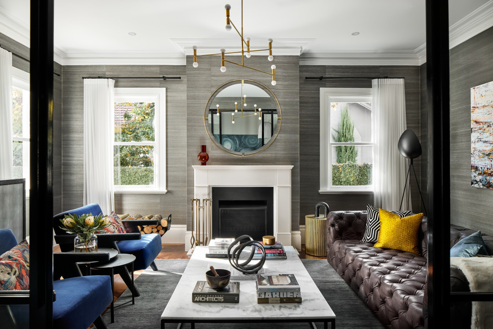 Идея дизайна: большая изолированная гостиная комната в стиле неоклассика (современная классика) с белыми стенами, светлым паркетным полом, двусторонним камином, фасадом камина из дерева, коричневым полом, обоями на стенах и коричневым диваном