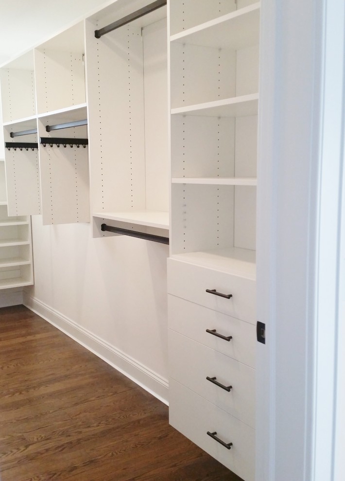 This is an example of a mid-sized transitional women's walk-in wardrobe in New York with flat-panel cabinets and white cabinets.