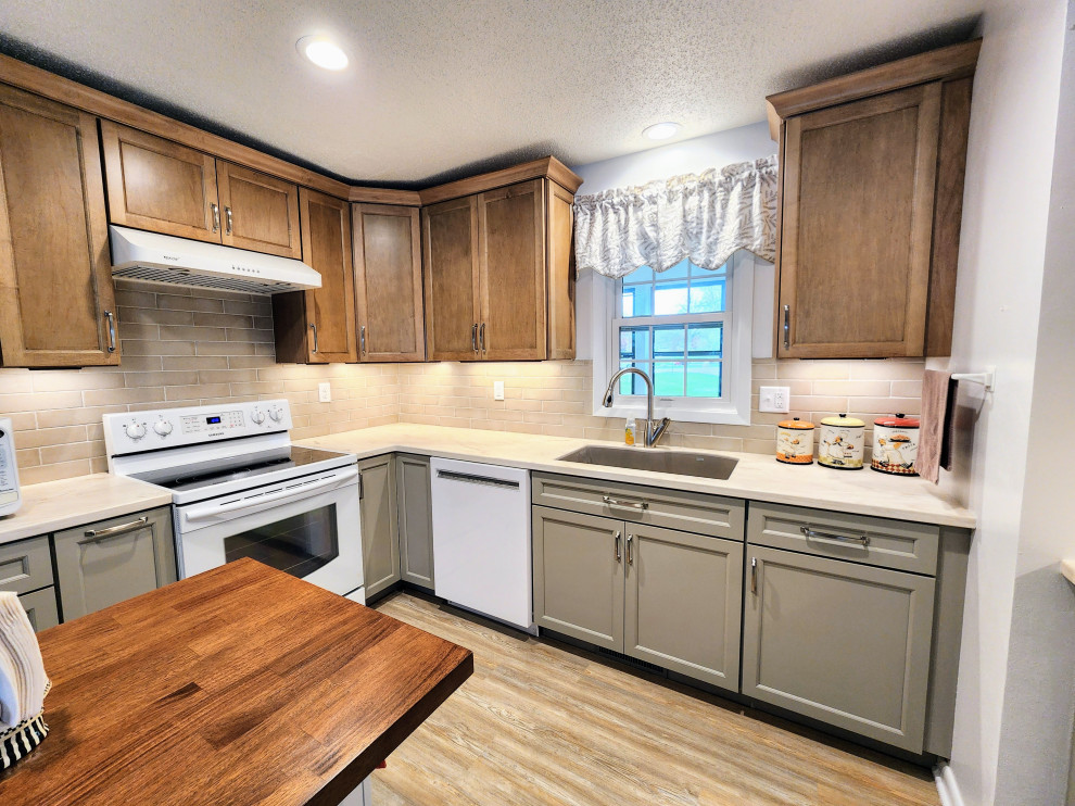 Inspiration for a mid-sized transitional l-shaped vinyl floor and multicolored floor eat-in kitchen remodel with an undermount sink, shaker cabinets, solid surface countertops, beige backsplash, subway tile backsplash, white appliances, an island and white countertops