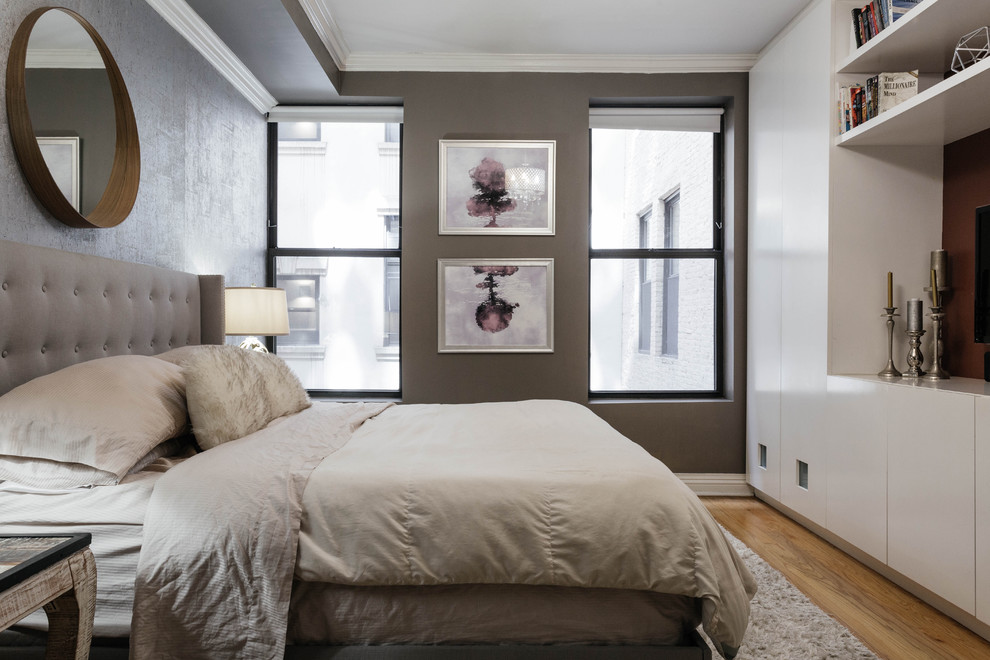 Inspiration for a mid-sized industrial master bedroom in New York with grey walls and medium hardwood floors.