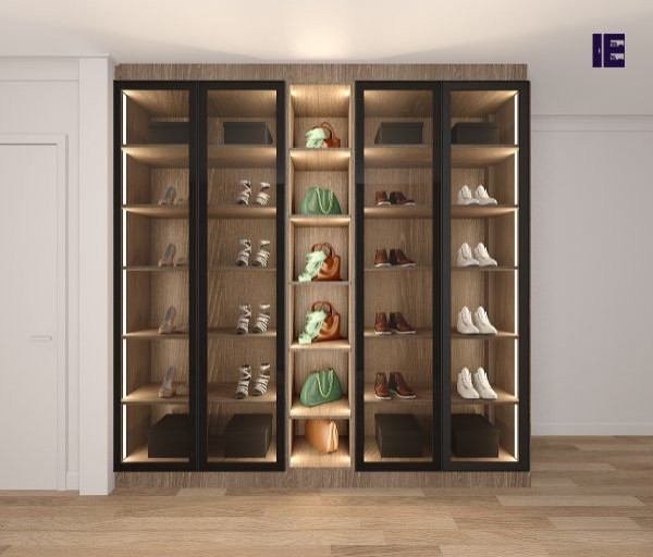 Large modern built-in wardrobe in London with glass-front cabinets, brown cabinets, plywood floors and brown floor.