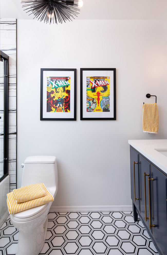 Small contemporary kids bathroom in New York with raised-panel cabinets, blue cabinets, an alcove tub, a shower/bathtub combo, a one-piece toilet, black and white tile, porcelain tile, white walls, porcelain floors, an integrated sink, engineered quartz benchtops, black floor, a sliding shower screen, white benchtops, a single vanity and a freestanding vanity.