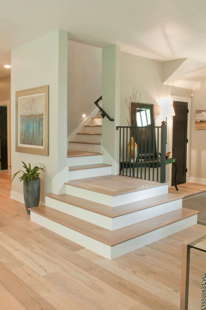 Mid-sized transitional wood straight staircase in Other with painted wood risers and wood railing.