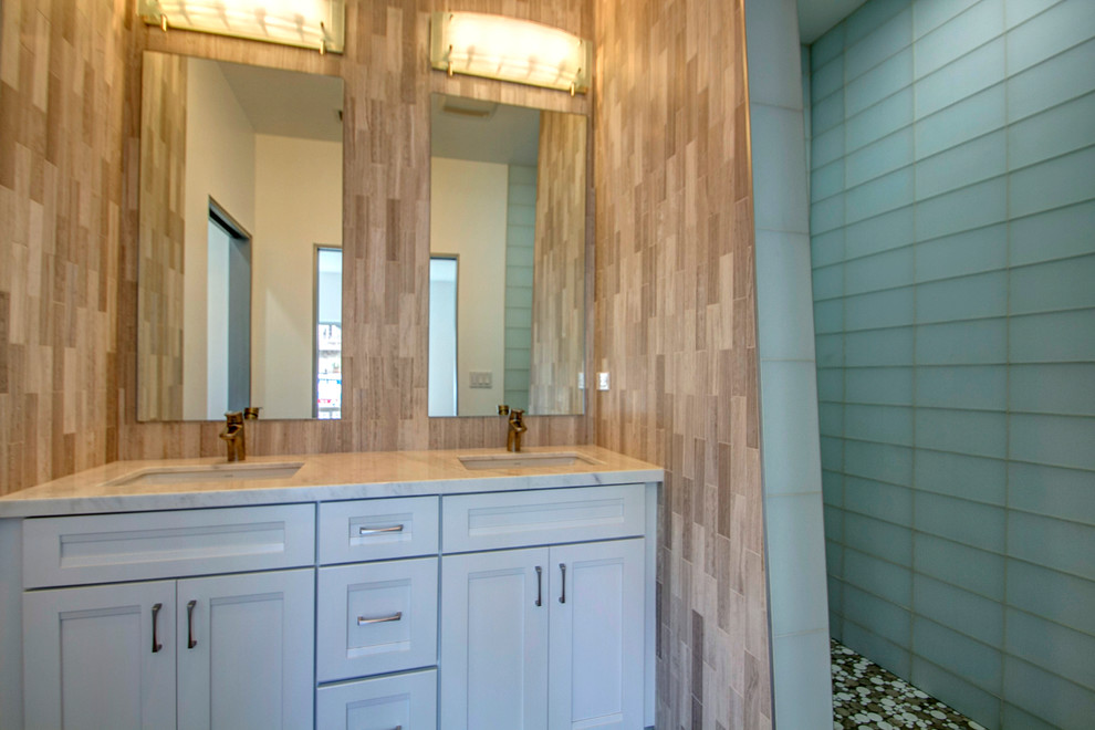 Doorless shower - large contemporary beige tile and stone tile doorless shower idea in San Diego with an undermount sink, white cabinets and marble countertops