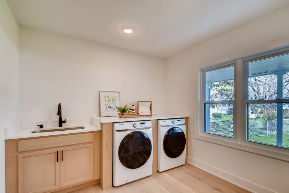 This is an example of a mid-sized contemporary laundry room in Minneapolis with light hardwood floors.