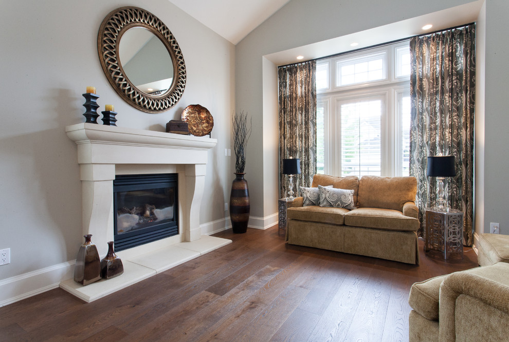 This is an example of a mid-sized traditional formal enclosed living room in Vancouver with grey walls, medium hardwood floors, a standard fireplace, a stone fireplace surround and no tv.