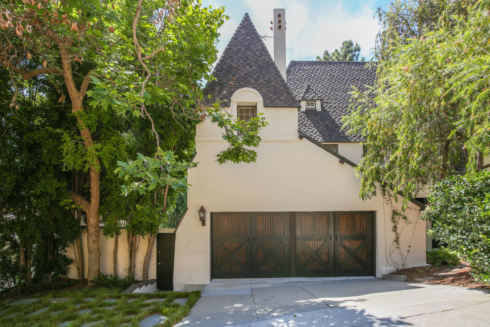 This is an example of a mid-sized traditional two-storey stucco beige exterior in Los Angeles with a clipped gable roof.
