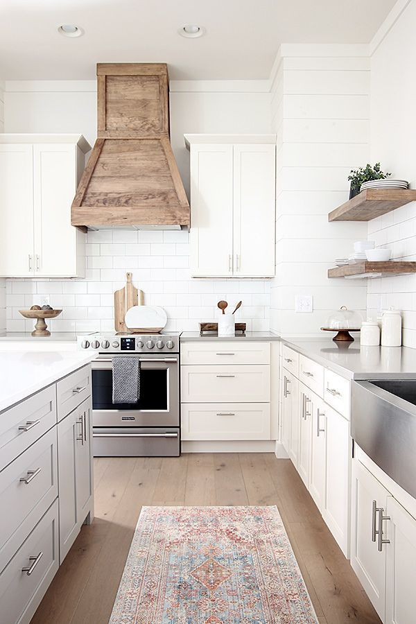 Design ideas for a large country l-shaped open plan kitchen in Columbus with a farmhouse sink, shaker cabinets, white cabinets, quartzite benchtops, white splashback, timber splashback, stainless steel appliances, light hardwood floors, with island, brown floor and white benchtop.