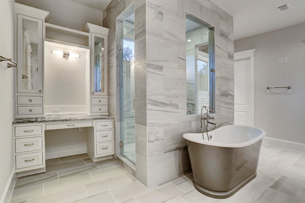 This is an example of a large arts and crafts master wet room bathroom in Houston with louvered cabinets, white cabinets, a freestanding tub, black and white tile, stone tile, grey walls, ceramic floors, an undermount sink, marble benchtops, multi-coloured floor and a hinged shower door.