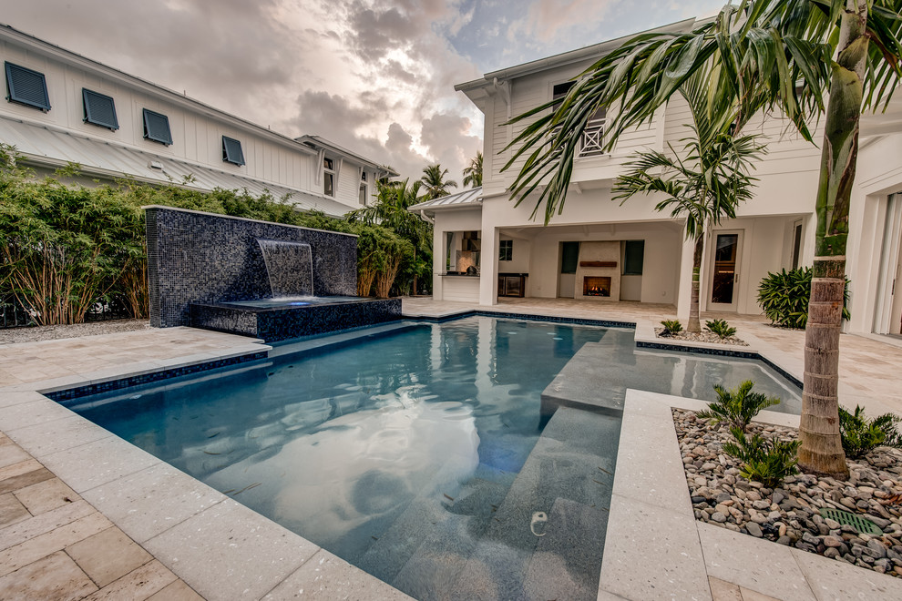 Photo of a large transitional courtyard custom-shaped natural pool in Other with a hot tub and natural stone pavers.