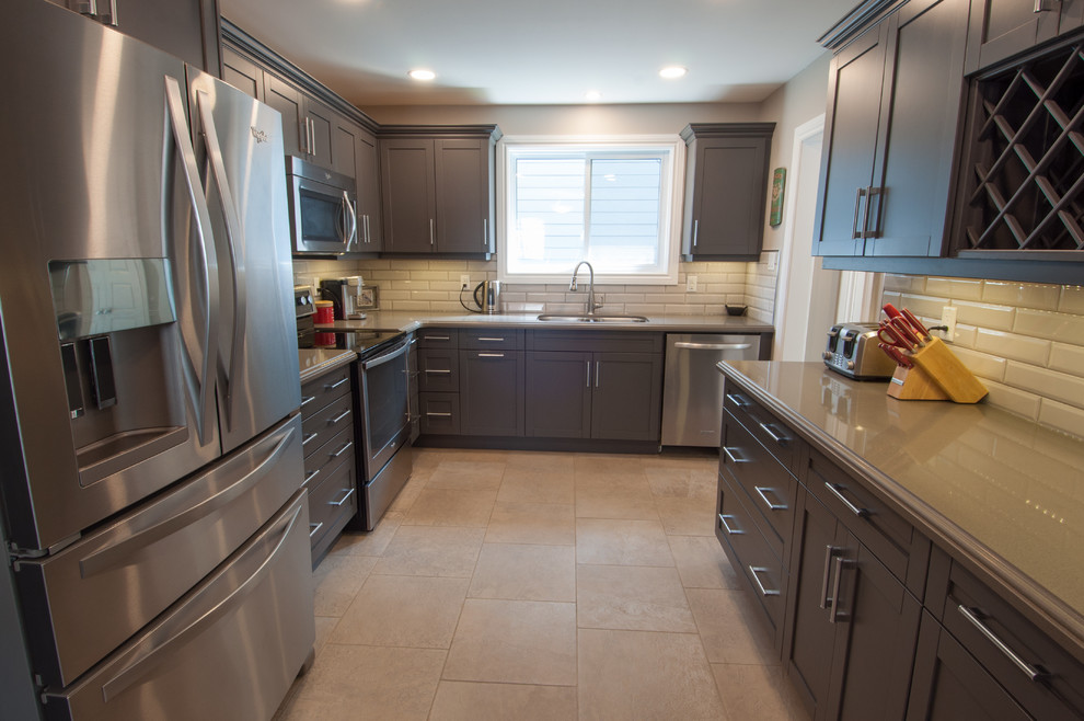Example of a mid-sized transitional u-shaped ceramic tile and beige floor enclosed kitchen design in Toronto with a double-bowl sink, shaker cabinets, dark wood cabinets, quartzite countertops, beige backsplash, subway tile backsplash, stainless steel appliances and no island