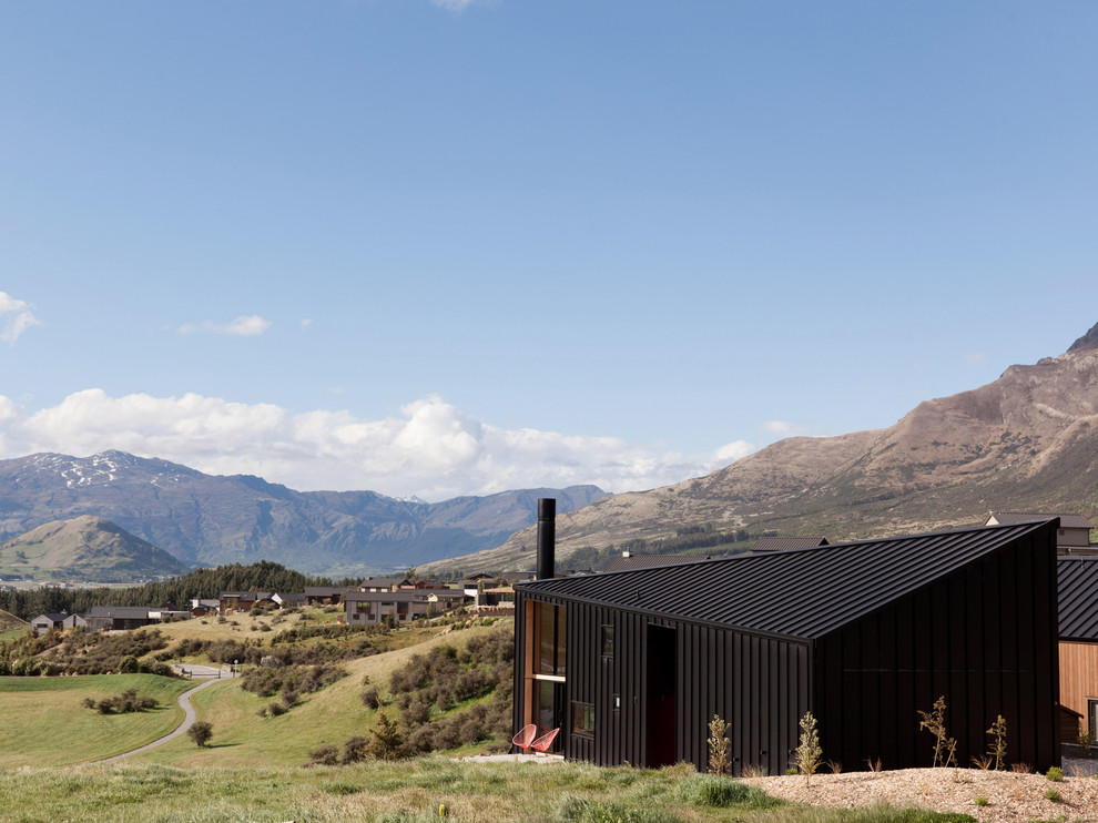 Small contemporary two-storey black exterior in Dunedin with metal siding and a gable roof.