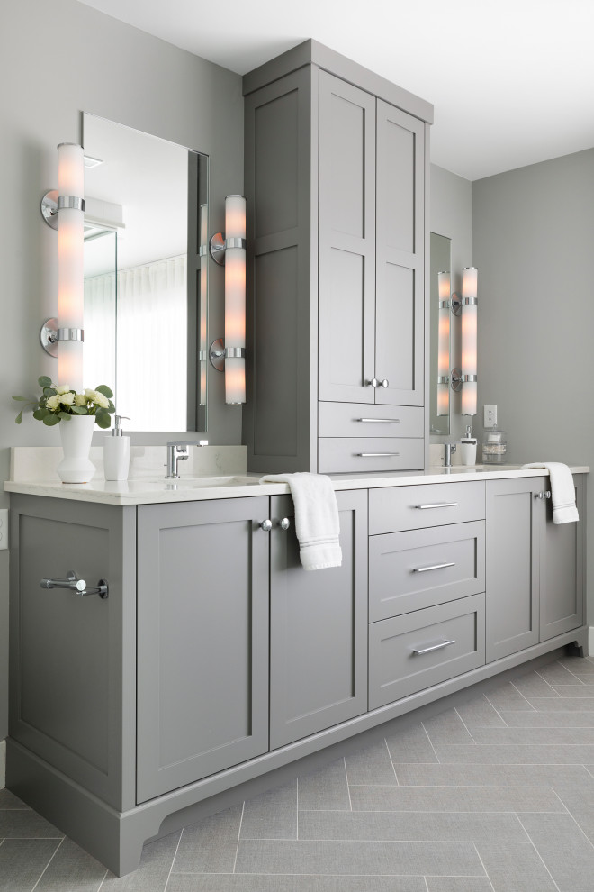 Inspiration for a large transitional master bathroom in Minneapolis with shaker cabinets, grey cabinets, a freestanding tub, an open shower, a one-piece toilet, grey walls, porcelain floors, an undermount sink, solid surface benchtops, grey floor, a hinged shower door, white benchtops, a shower seat, a double vanity and a built-in vanity.