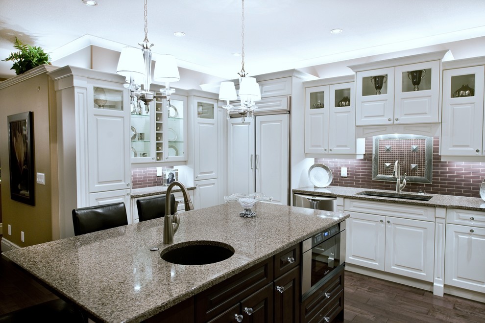 Inspiration for a large victorian l-shaped medium tone wood floor open concept kitchen remodel with a drop-in sink, white cabinets, granite countertops, brown backsplash, stainless steel appliances and an island