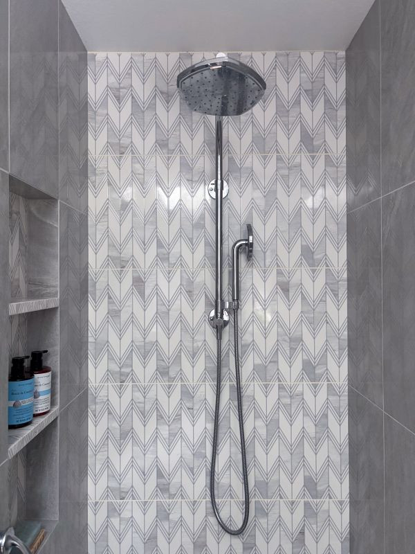 Example of a transitional master multicolored tile vinyl floor, brown floor and double-sink corner shower design with shaker cabinets, white cabinets, blue walls, an undermount sink, quartz countertops, a hinged shower door, white countertops and a built-in vanity