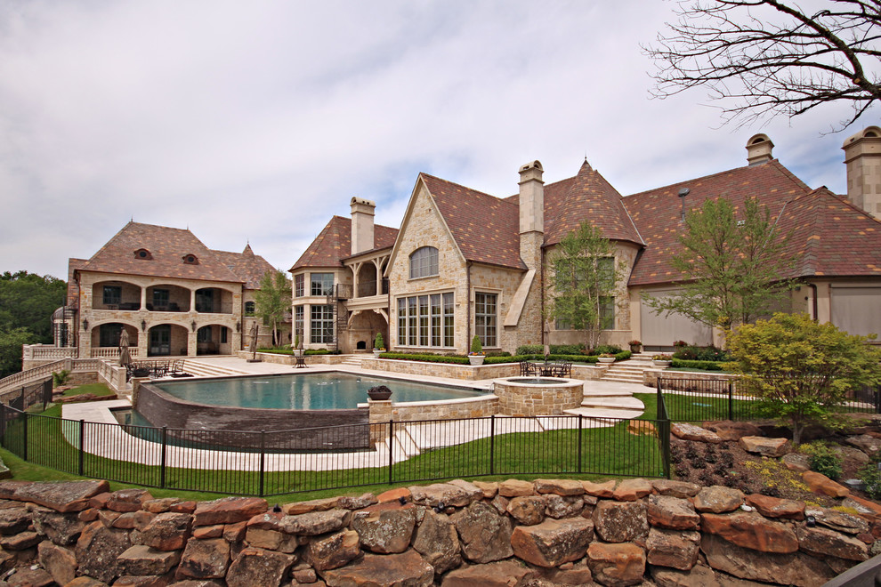 Inspiration for an expansive traditional two-storey stucco beige house exterior in Dallas with a tile roof.