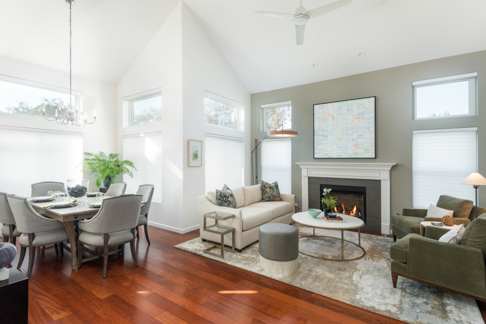 This is an example of a mid-sized transitional formal open concept living room in San Francisco with green walls, light hardwood floors, a standard fireplace, a tile fireplace surround, no tv, red floor and vaulted.