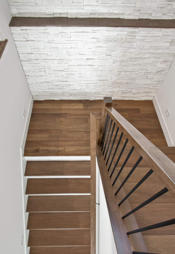 Foto de escalera en U clásica renovada con contrahuellas de madera pintada, barandilla de varios materiales y todos los tratamientos de pared