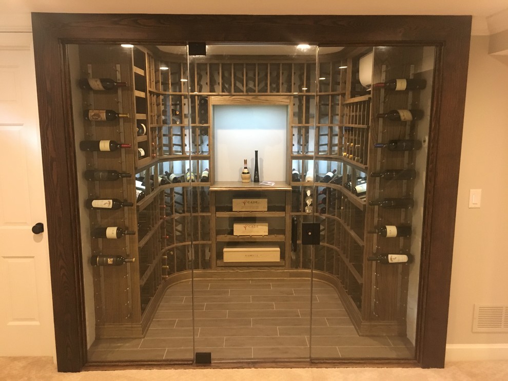 Mid-sized traditional wine cellar in Cincinnati with porcelain floors, storage racks and brown floor.