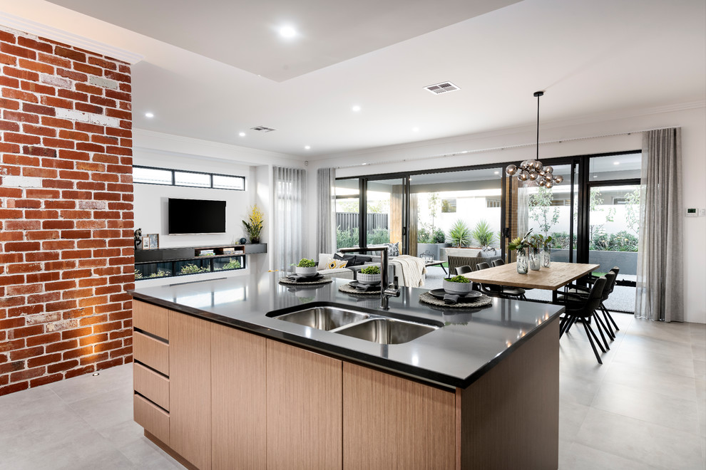 Mid-sized contemporary galley open plan kitchen in Perth with a double-bowl sink, medium wood cabinets, solid surface benchtops, ceramic floors, with island, grey floor and black benchtop.