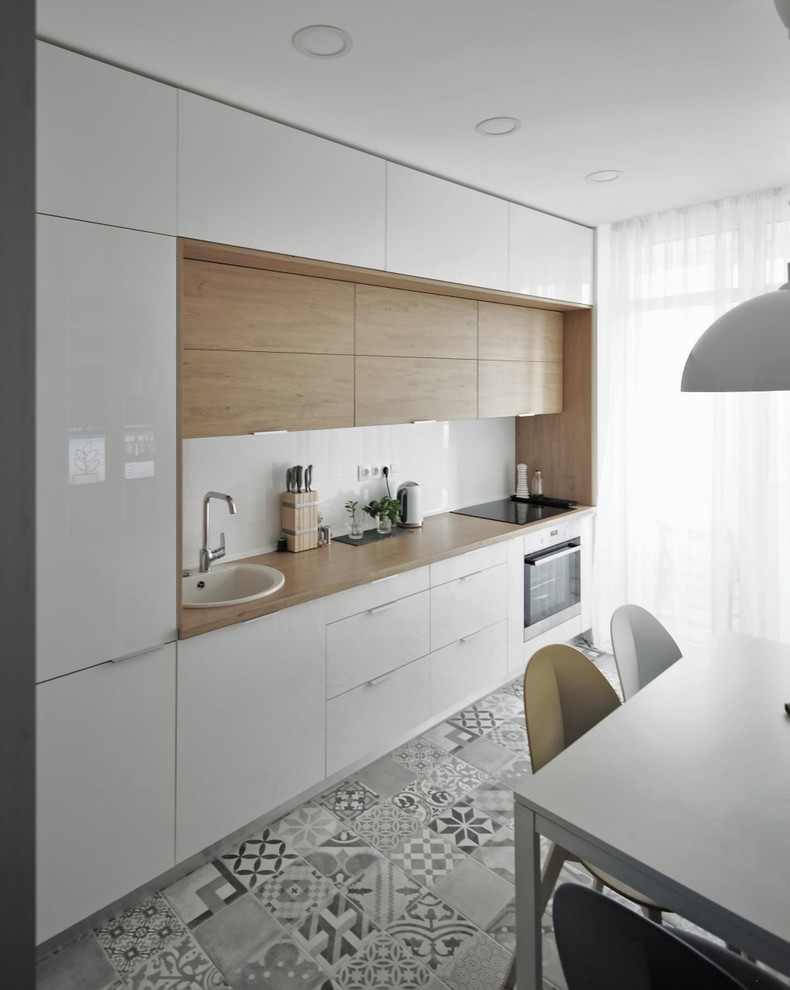 Inspiration for a mid-sized contemporary single-wall open plan kitchen in Other with a drop-in sink, flat-panel cabinets, white cabinets, laminate benchtops, white splashback, porcelain splashback, stainless steel appliances, porcelain floors and no island.