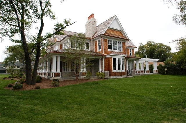 Photo of a large traditional two-storey brown exterior in Chicago with wood siding.