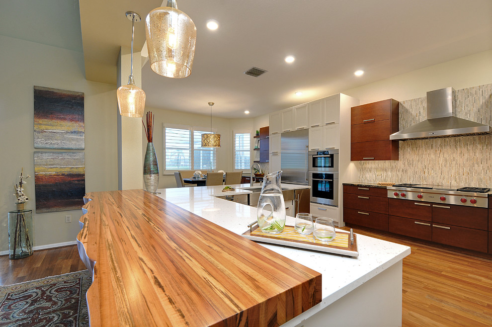 Open concept kitchen - large transitional l-shaped dark wood floor open concept kitchen idea in Tampa with a farmhouse sink, gray backsplash, matchstick tile backsplash, stainless steel appliances and an island