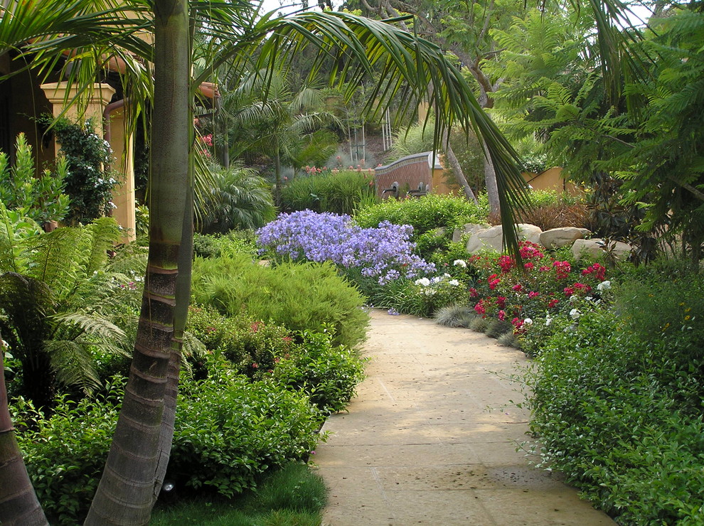 This is an example of a mid-sized mediterranean garden in Santa Barbara with concrete pavers and with rock feature.