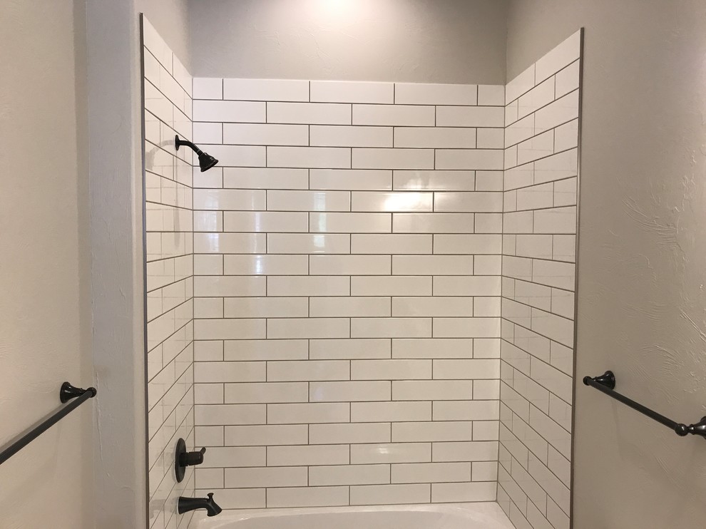 Example of a transitional white tile and subway tile alcove shower design in Denver with gray walls