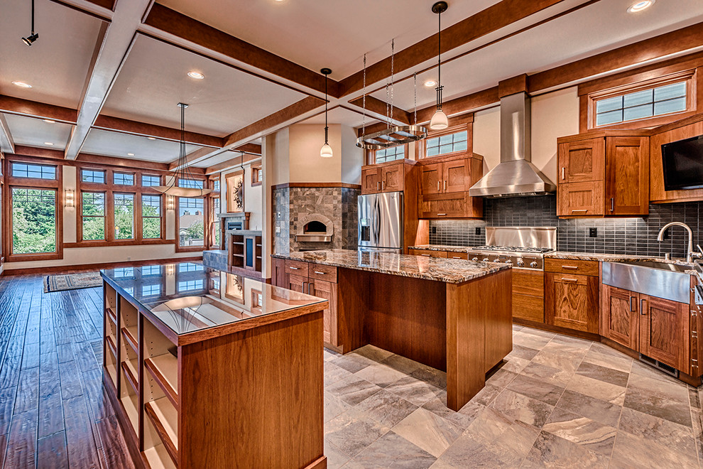 Photo of an arts and crafts l-shaped open plan kitchen in Seattle with a farmhouse sink, shaker cabinets, medium wood cabinets, granite benchtops, black splashback, stainless steel appliances and with island.
