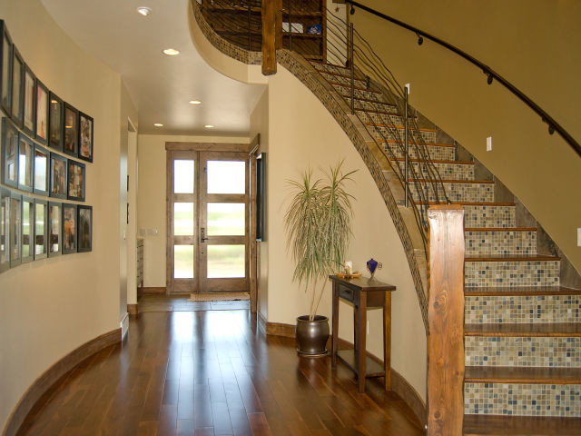 This is an example of a large country entry hall in Salt Lake City with yellow walls, dark hardwood floors, a single front door and a medium wood front door.