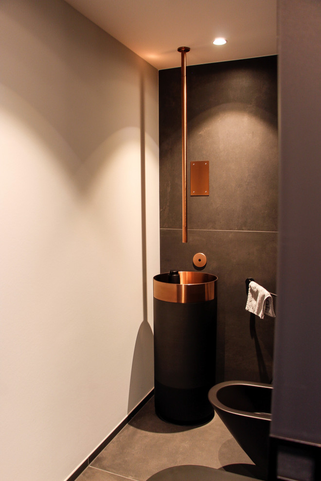 Badezimmer With schwarzen Fliesen, grauem Boden, Einzelwaschbecken and freistehendem Waschtisch in Dusseldorf