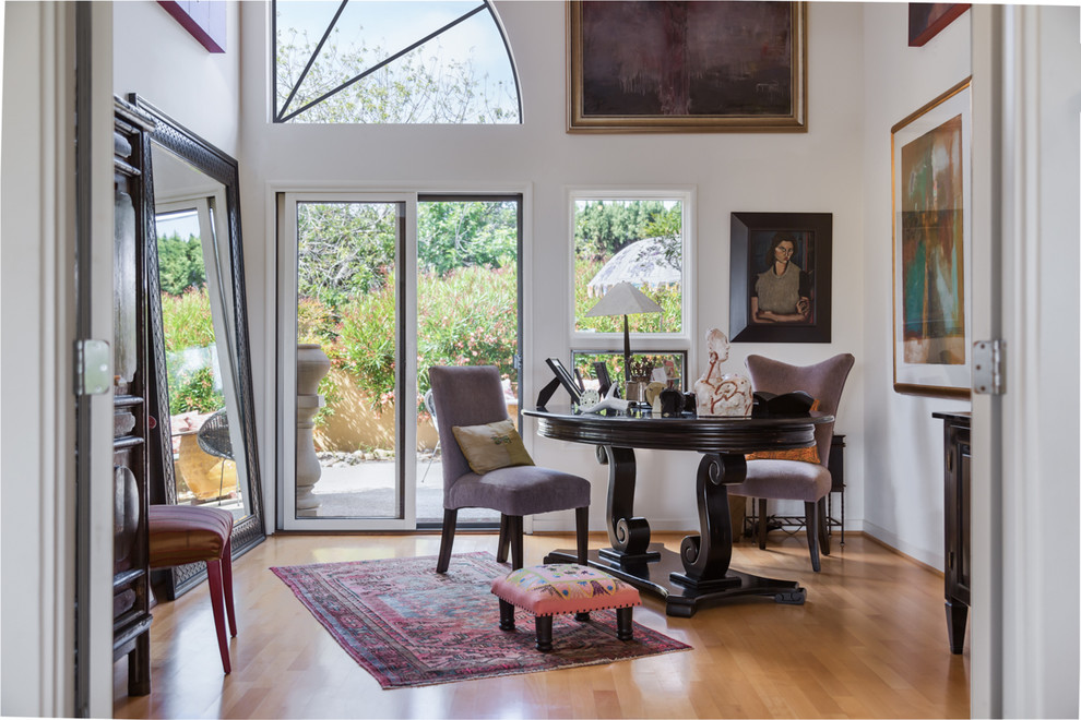 This is an example of a traditional study room in Santa Barbara with white walls, medium hardwood floors, a freestanding desk and yellow floor.