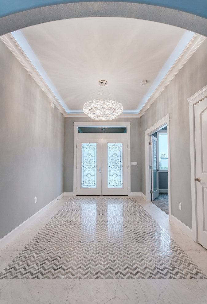 Example of a large transitional marble floor and white floor entry hall design in Seattle with gray walls and a white front door