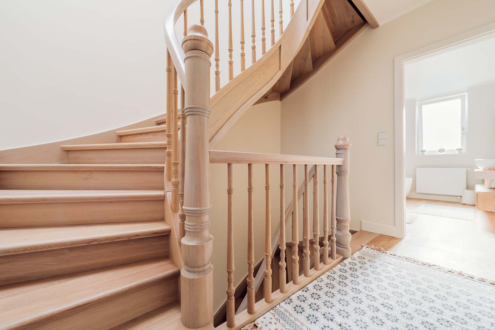 Классическая лестница из дуба с изогнутыми перилами