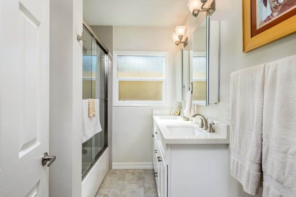 Photo of a mid-sized transitional 3/4 bathroom in Orange County with an alcove tub, a shower/bathtub combo, beige walls, an undermount sink, a sliding shower screen, white cabinets, beige tile, subway tile, engineered quartz benchtops and shaker cabinets.