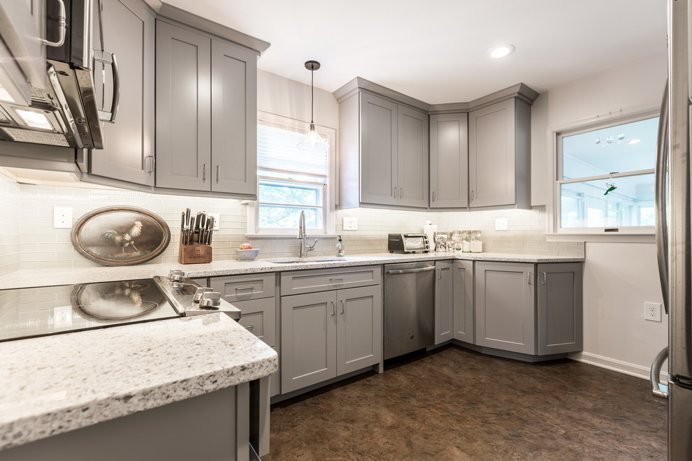 Inspiration for a small transitional galley separate kitchen in DC Metro with a double-bowl sink, shaker cabinets, grey cabinets, glass tile splashback, stainless steel appliances, no island, brown floor and grey benchtop.