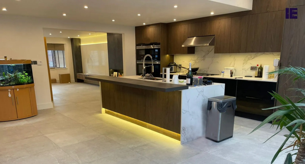 Design ideas for a large contemporary single-wall kitchen/diner in London with a single-bowl sink, flat-panel cabinets, medium wood cabinets, granite worktops, white splashback, a breakfast bar and a chimney breast.