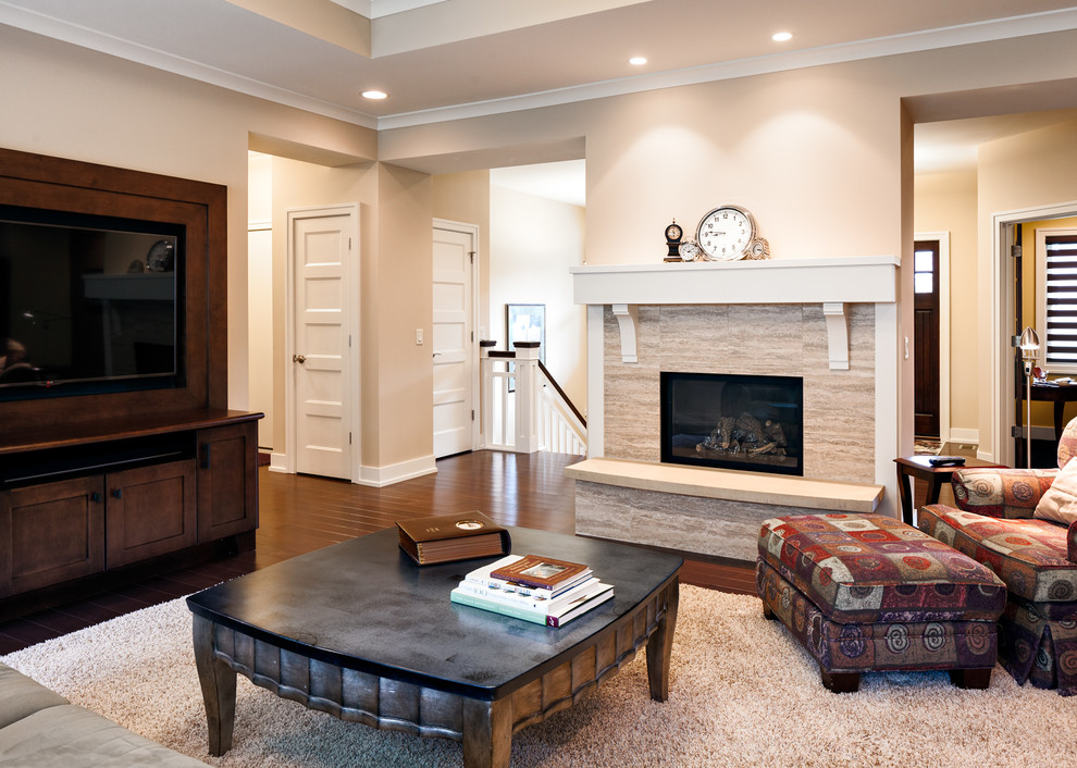 Inspiration for a mid-sized arts and crafts enclosed living room in Grand Rapids with beige walls, dark hardwood floors, a standard fireplace, a stone fireplace surround and a built-in media wall.