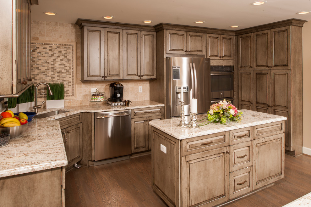 Inspiration for a large traditional l-shaped eat-in kitchen in Detroit with a single-bowl sink, distressed cabinets, granite benchtops, beige splashback, stainless steel appliances, medium hardwood floors, multiple islands, raised-panel cabinets and stone tile splashback.
