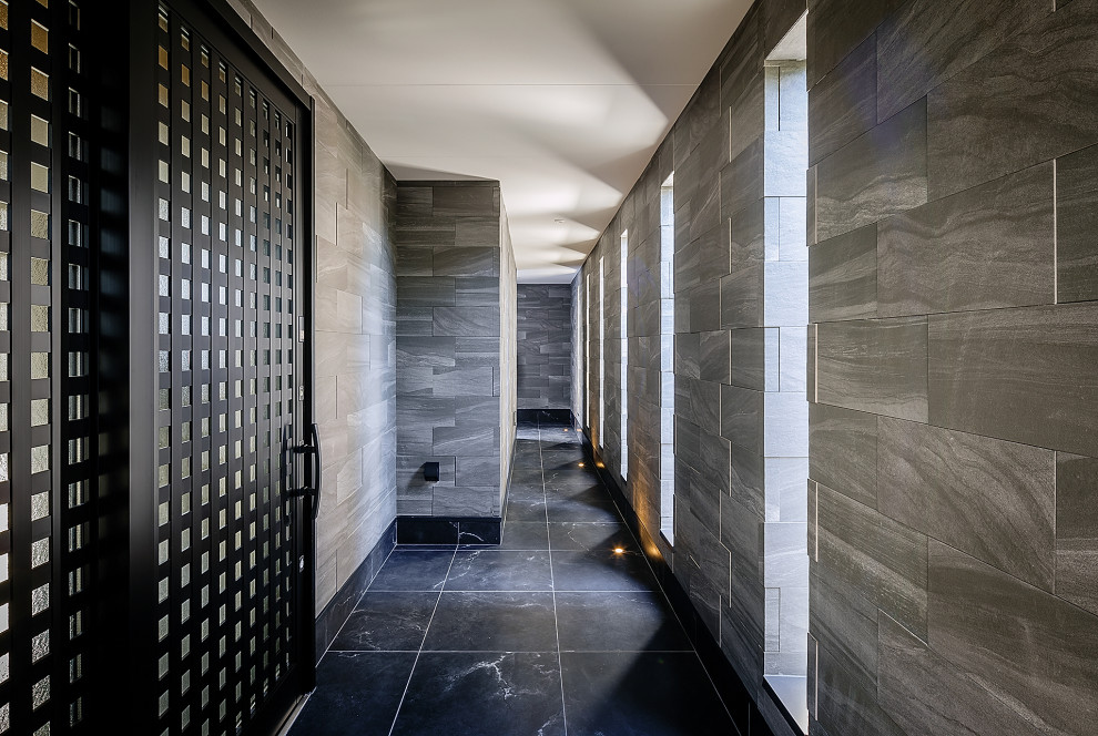 Ispirazione per un ampio ingresso o corridoio minimalista con pareti grigie, pavimento con piastrelle in ceramica, pavimento nero e soffitto in perlinato