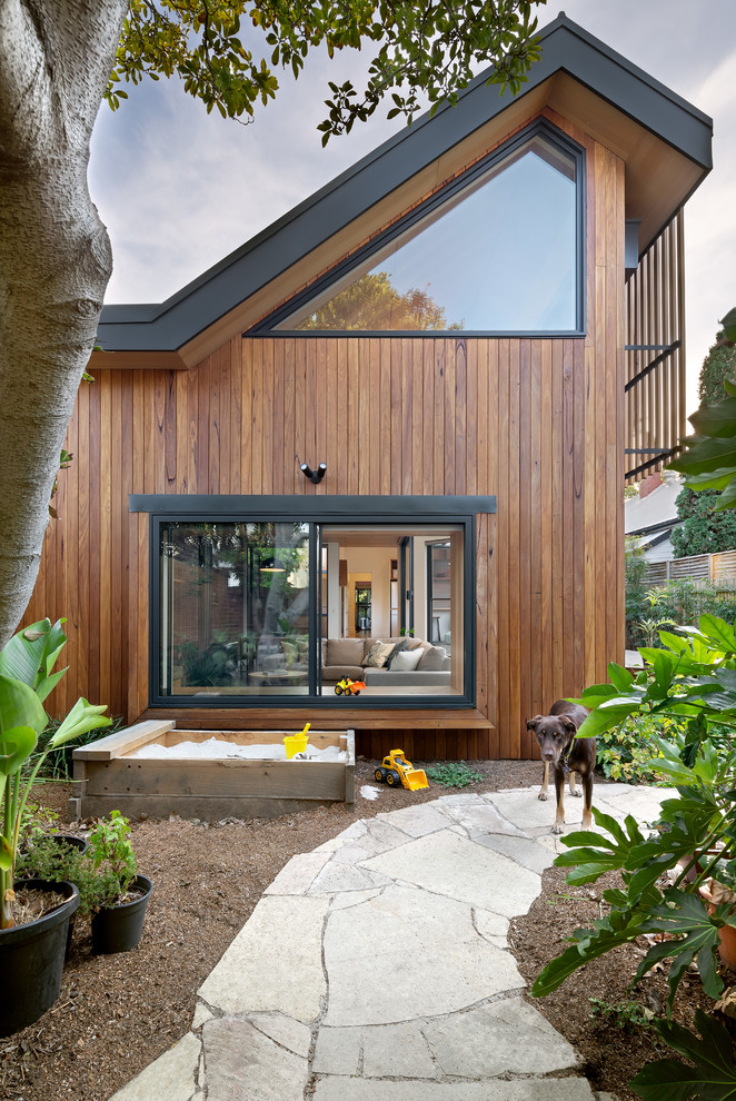 Contemporary backyard garden in Melbourne with a garden path and natural stone pavers.